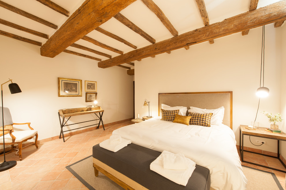 Ejemplo de dormitorio mediterráneo grande con paredes blancas y suelo de baldosas de cerámica
