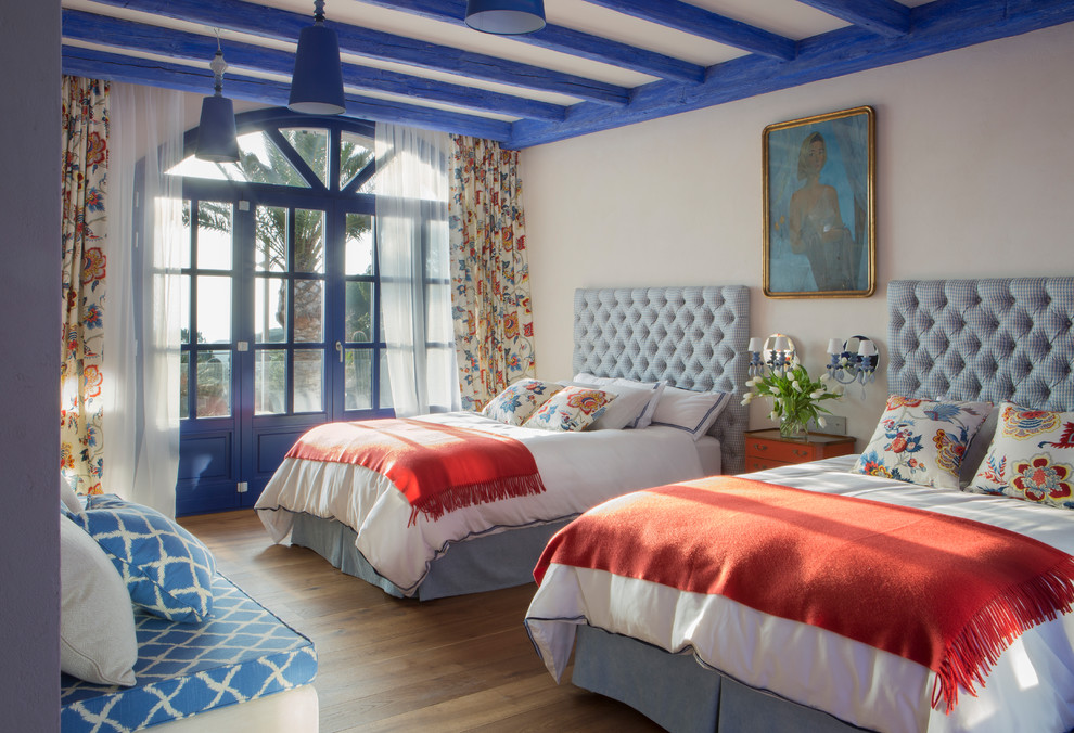 他の地域にある中くらいな地中海スタイルのおしゃれな客用寝室 (白い壁、濃色無垢フローリング、暖炉なし、茶色い床) のインテリア