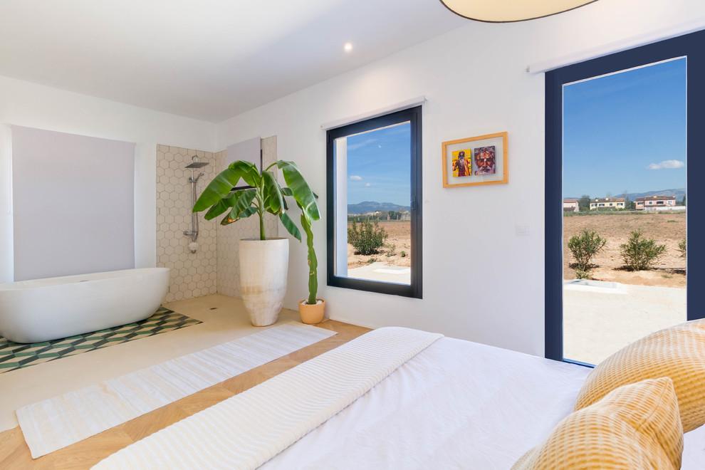 На фото: хозяйская спальня в средиземноморском стиле с белыми стенами, светлым паркетным полом и бежевым полом без камина