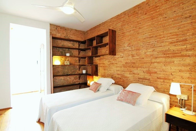Modelo de habitación de invitados urbana de tamaño medio con paredes blancas y suelo de madera en tonos medios