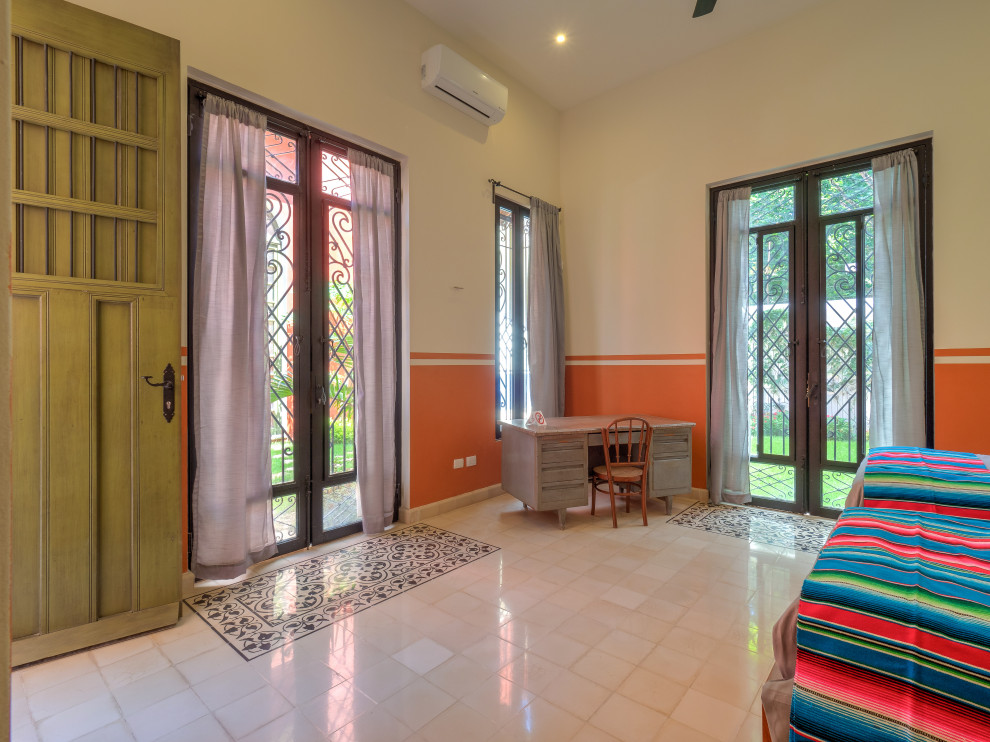 Idée de décoration pour une chambre d'amis tradition de taille moyenne avec un mur orange, sol en béton ciré et un sol blanc.