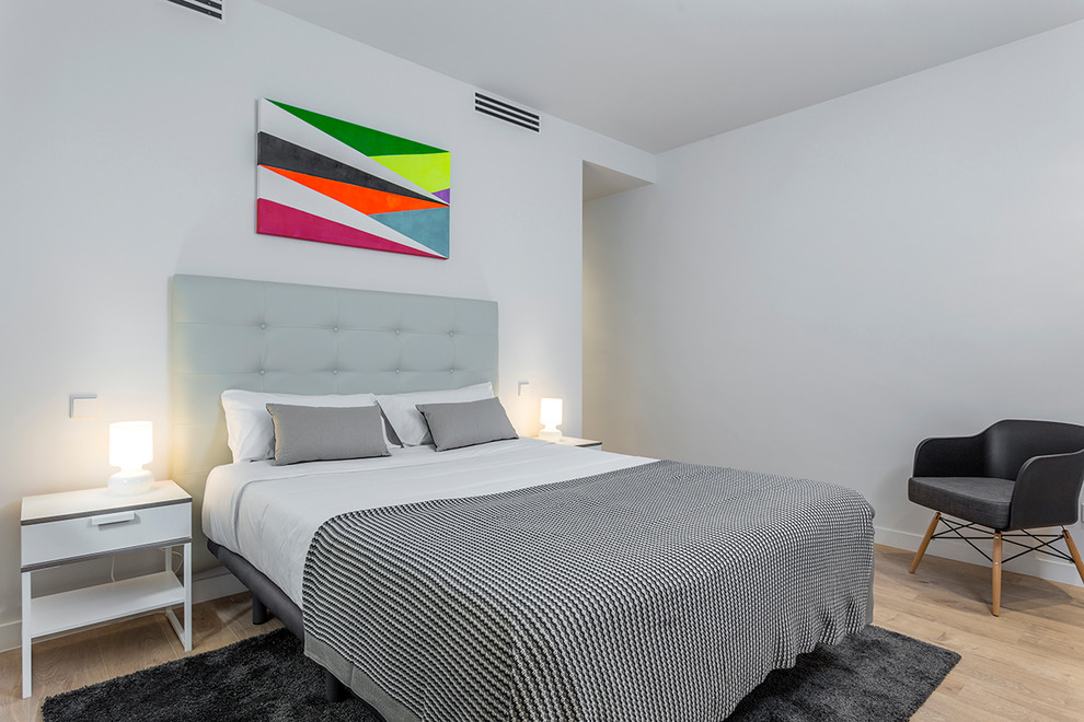 Foto de dormitorio escandinavo con paredes grises y suelo de madera clara