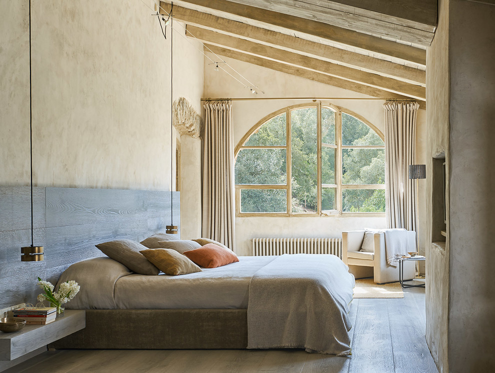 Ejemplo de dormitorio mediterráneo con suelo de madera en tonos medios