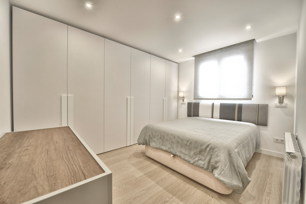 Imagen de dormitorio principal escandinavo de tamaño medio con paredes blancas y suelo laminado