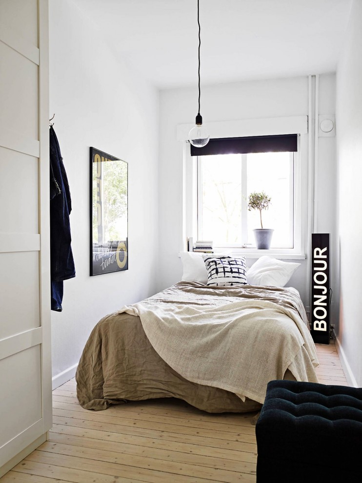Exempel på ett litet minimalistiskt gästrum, med vita väggar och ljust trägolv