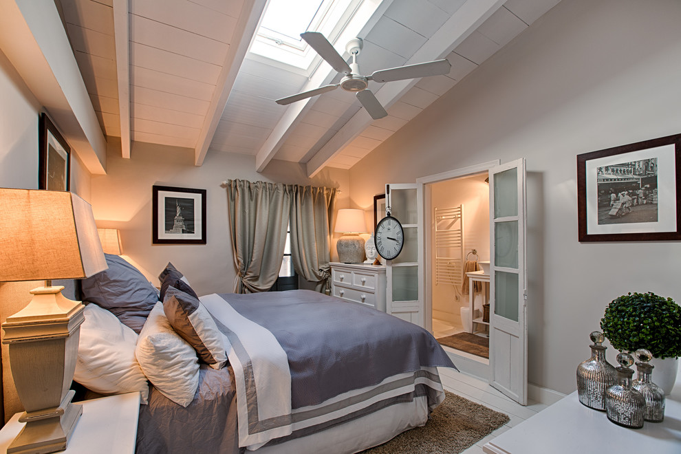 Modelo de dormitorio principal tradicional renovado de tamaño medio sin chimenea con paredes blancas y suelo de madera pintada