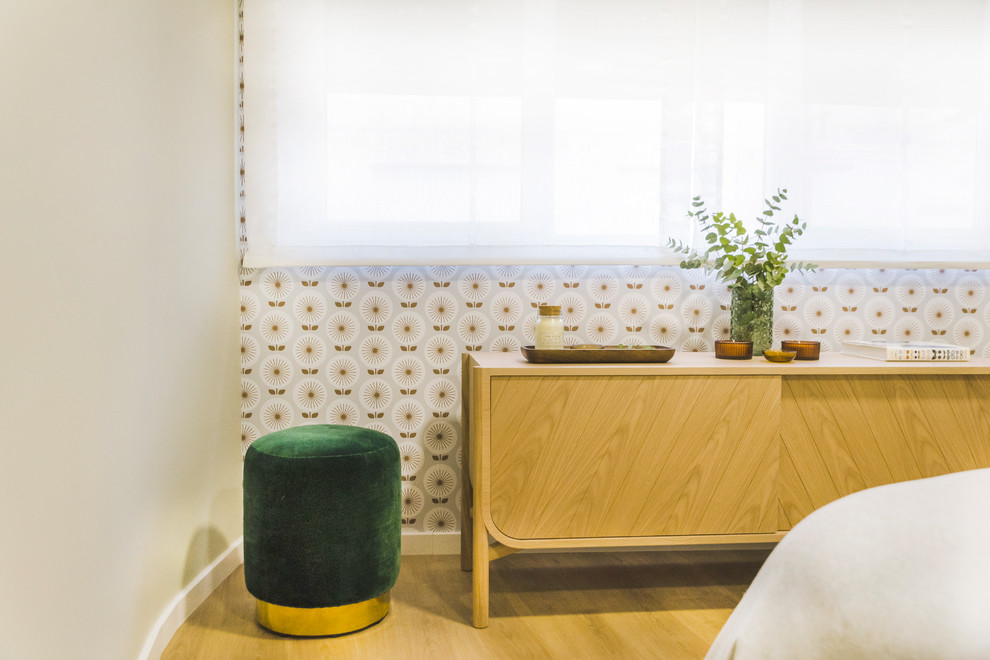 Modelo de dormitorio principal escandinavo grande sin chimenea con paredes beige, suelo de madera en tonos medios y suelo marrón