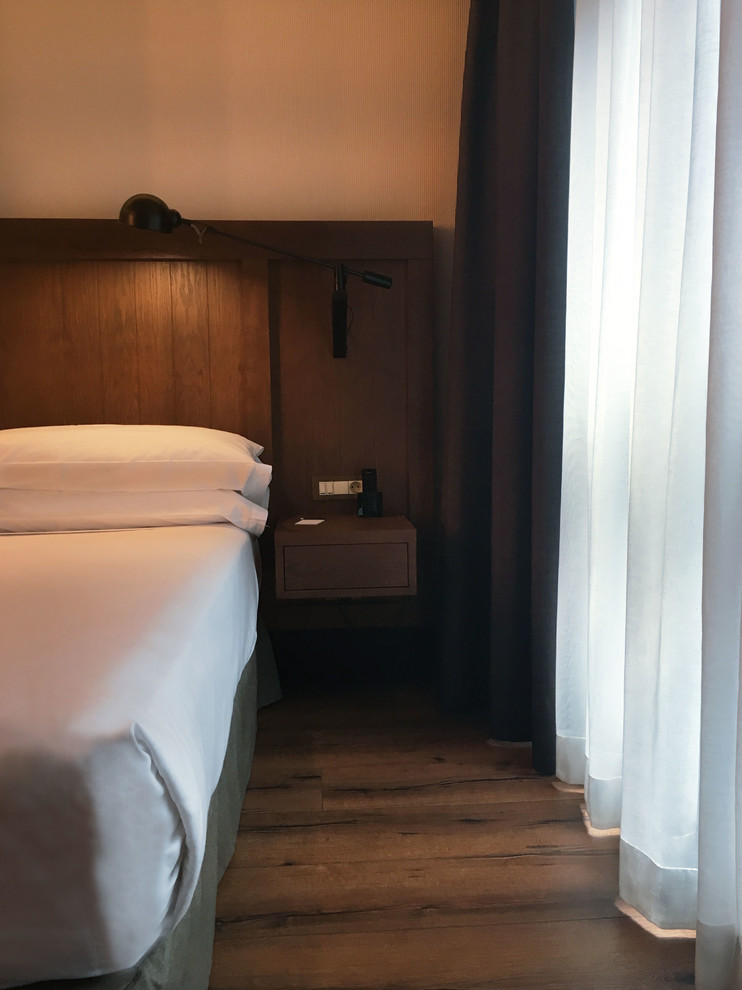 Ejemplo de dormitorio grande sin chimenea con paredes beige, suelo de madera oscura y suelo marrón