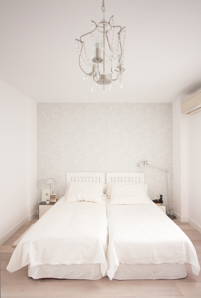 Ejemplo de habitación de invitados clásica renovada de tamaño medio sin chimenea con paredes blancas, suelo de madera clara y suelo beige