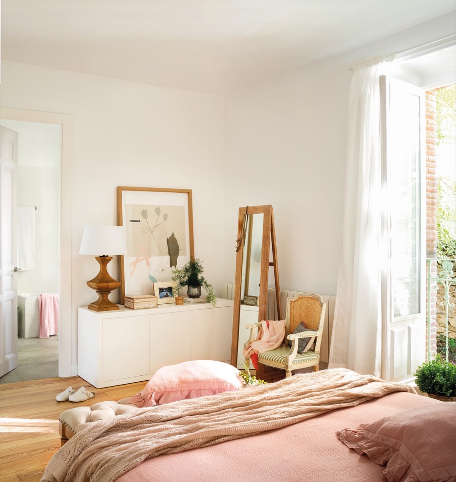 Modelo de dormitorio principal romántico de tamaño medio sin chimenea con paredes blancas y suelo de madera en tonos medios