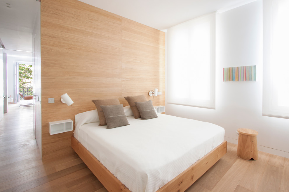Foto de dormitorio principal moderno pequeño con paredes blancas y suelo de madera clara