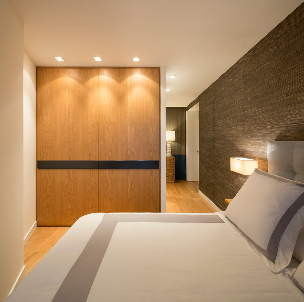 Foto de dormitorio principal actual de tamaño medio sin chimenea con paredes blancas y suelo de madera en tonos medios