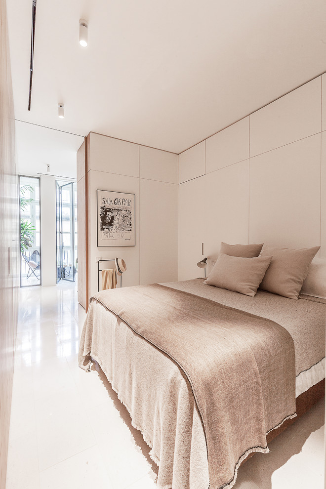 This is an example of a contemporary bedroom in Barcelona with white walls and white floors.