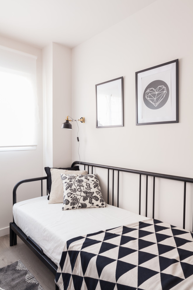 Small danish guest laminate floor and gray floor bedroom photo in Madrid with beige walls