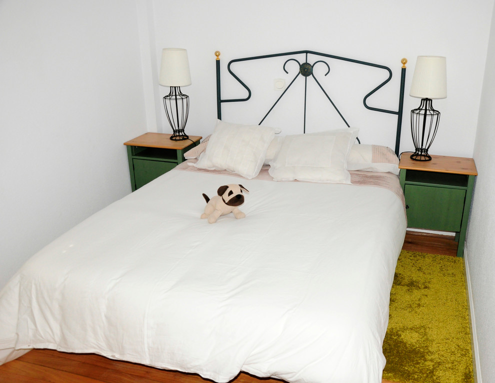 Diseño de dormitorio principal tradicional renovado pequeño con paredes blancas y suelo de madera en tonos medios