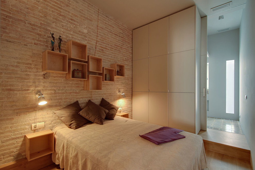 Mittelgroßes Industrial Hauptschlafzimmer ohne Kamin mit braunem Holzboden in Sonstige