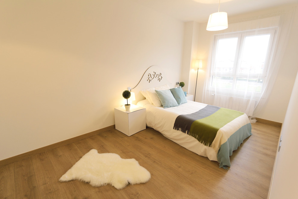 Imagen de dormitorio principal nórdico grande sin chimenea con paredes blancas y suelo de madera en tonos medios