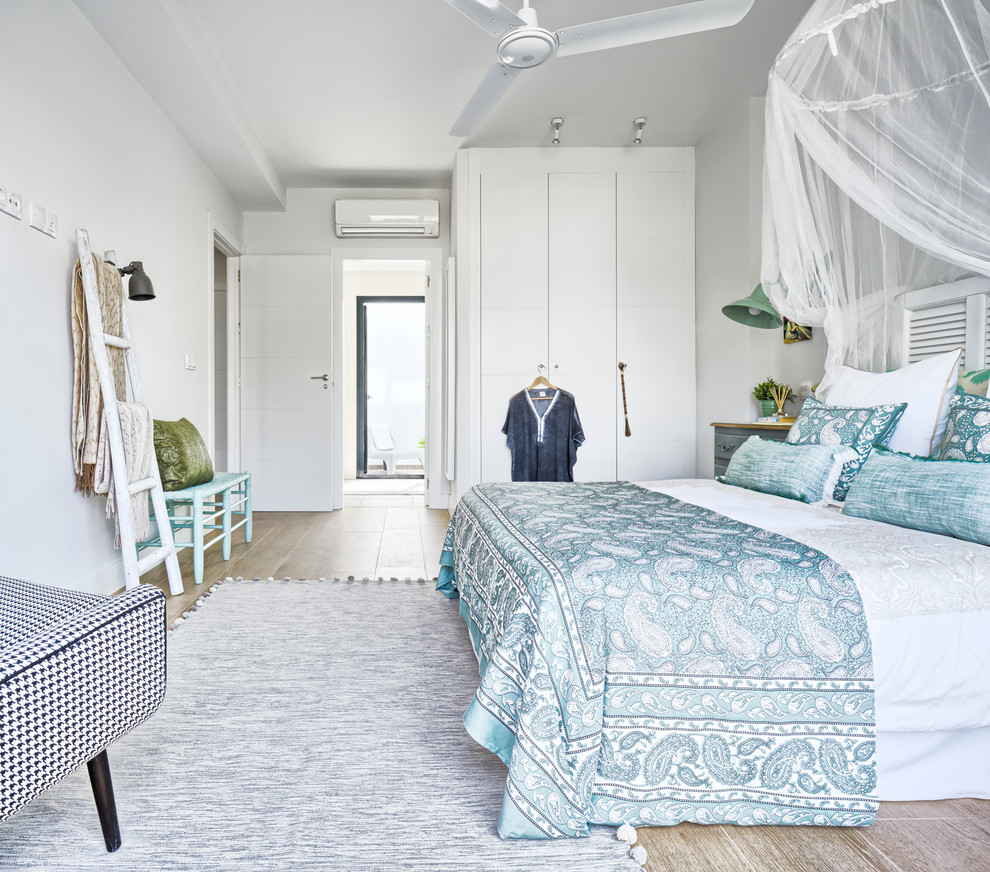 Immagine di una camera matrimoniale stile marino di medie dimensioni con pareti bianche e pavimento in gres porcellanato