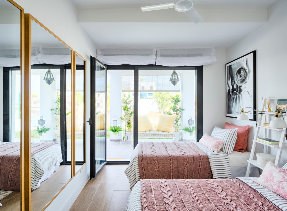 Ejemplo de habitación de invitados costera de tamaño medio con paredes blancas y suelo de baldosas de porcelana
