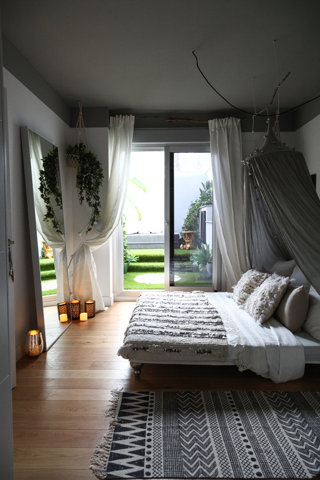 Imagen de dormitorio principal escandinavo de tamaño medio con paredes blancas y suelo de madera en tonos medios