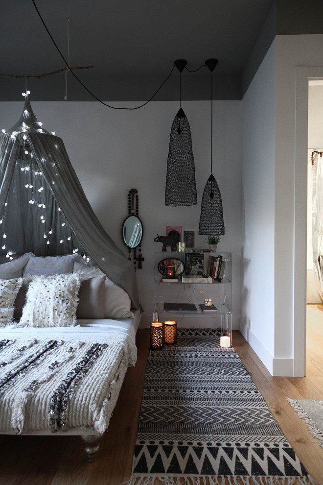 Foto de dormitorio principal nórdico de tamaño medio con paredes blancas y suelo de madera en tonos medios