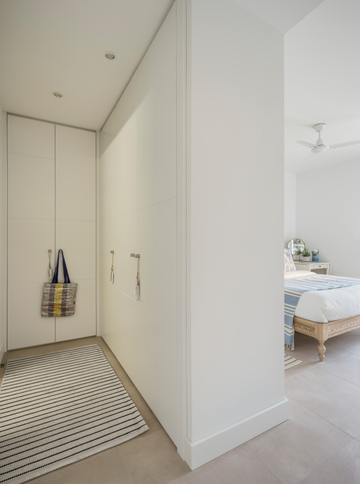 Mittelgroßes Mediterranes Hauptschlafzimmer mit weißer Wandfarbe, Porzellan-Bodenfliesen und beigem Boden in Sonstige