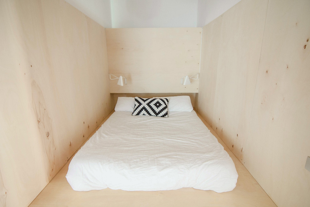 Foto de dormitorio principal actual pequeño sin chimenea con paredes beige y suelo de madera clara