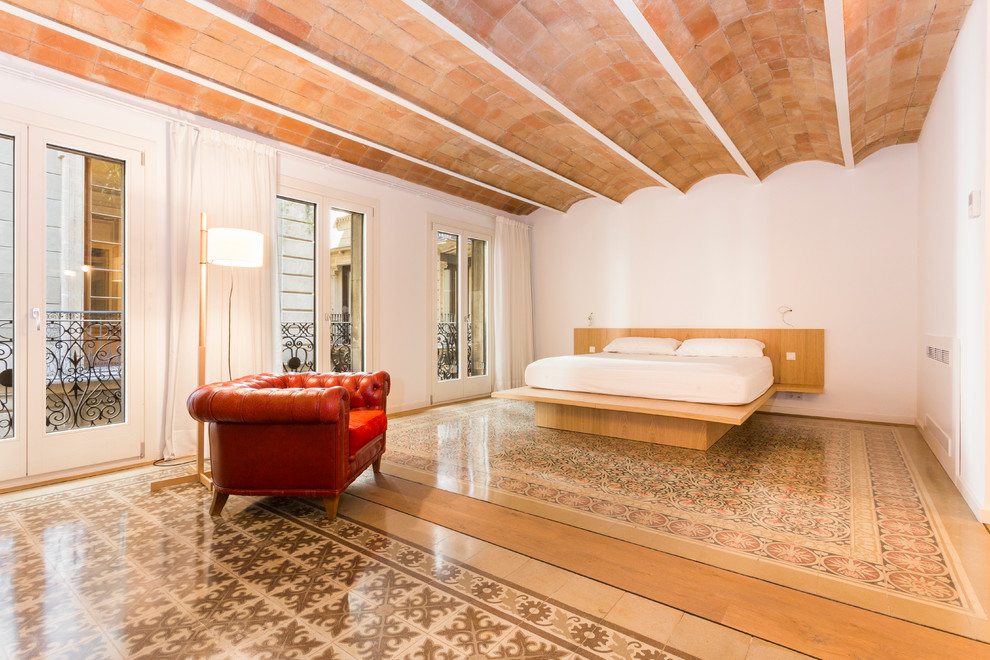 Modelo de dormitorio principal mediterráneo extra grande sin chimenea con paredes blancas y suelo de baldosas de cerámica