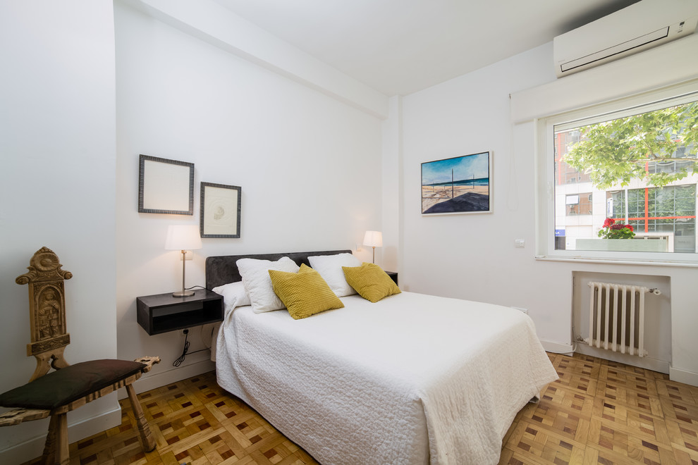 Bedroom - mediterranean guest medium tone wood floor and brown floor bedroom idea in Madrid with white walls