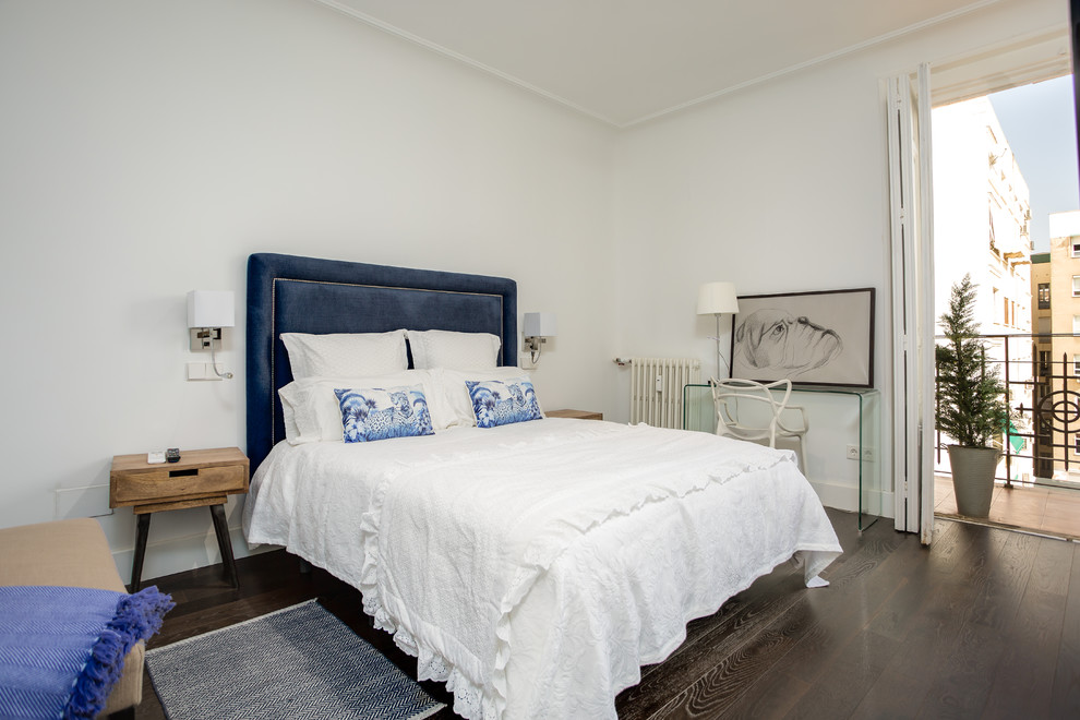 Eklektisches Gästezimmer mit weißer Wandfarbe, dunklem Holzboden und braunem Boden in Madrid