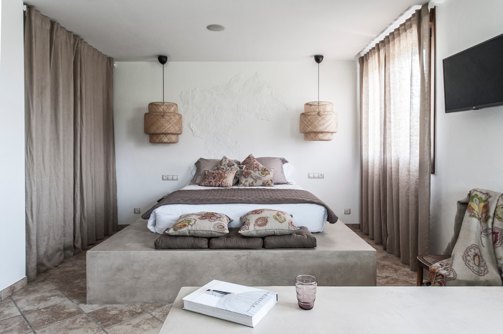 Diseño de dormitorio principal mediterráneo de tamaño medio sin chimenea con paredes blancas y suelo de baldosas de terracota