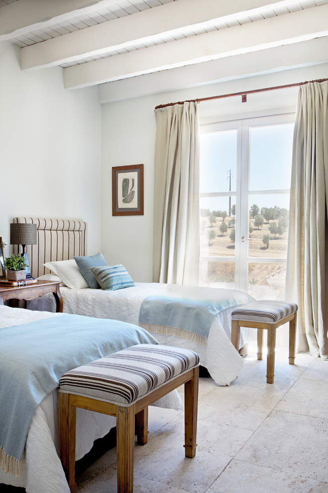Стильный дизайн: гостевая спальня (комната для гостей) в средиземноморском стиле с белыми стенами и бежевым полом - последний тренд