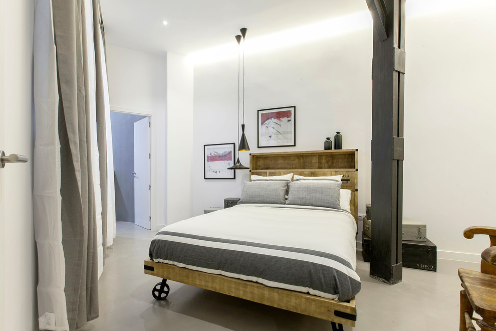 На фото: хозяйская спальня среднего размера в стиле лофт с белыми стенами и бетонным полом без камина