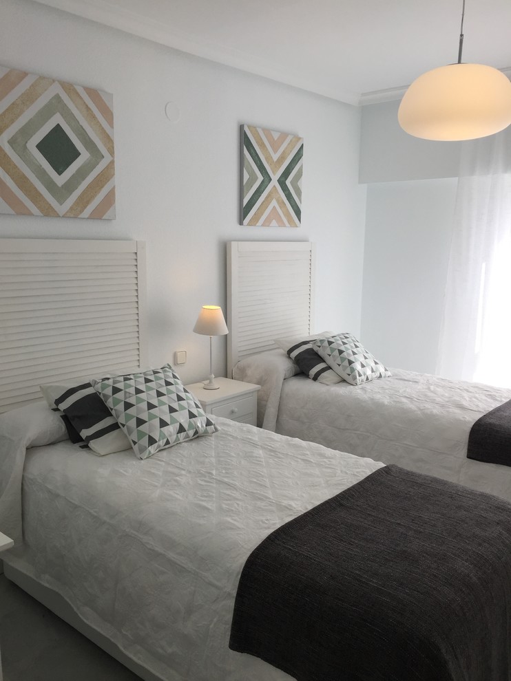 Modelo de habitación de invitados mediterránea de tamaño medio con paredes blancas