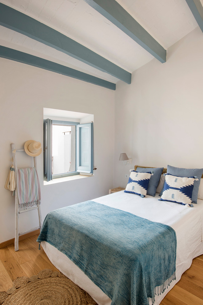 На фото: хозяйская спальня среднего размера в средиземноморском стиле с белыми стенами, паркетным полом среднего тона и коричневым полом без камина