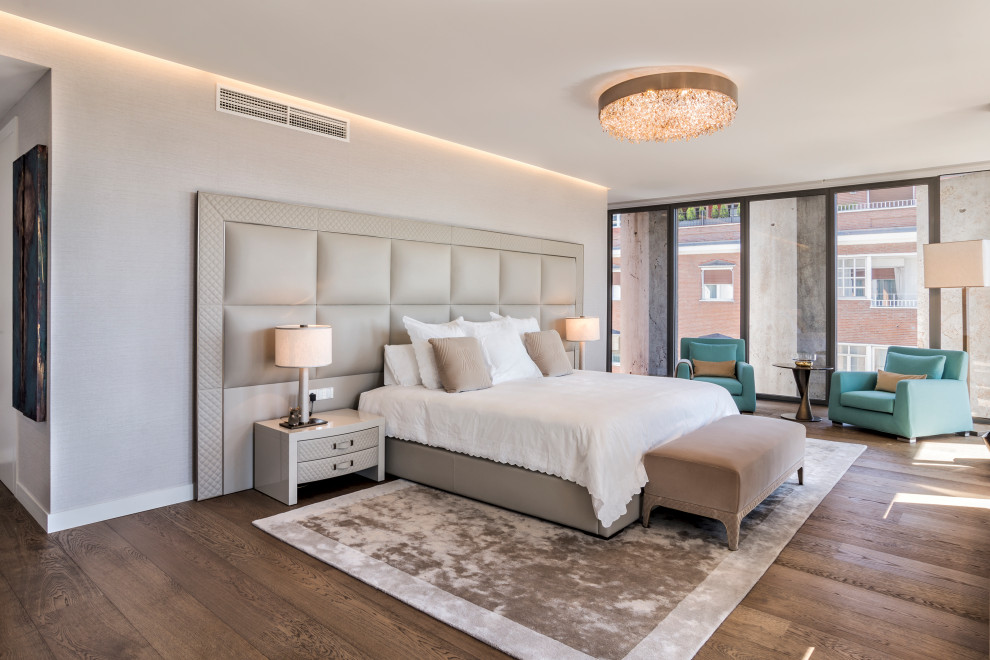 Modernes Schlafzimmer mit grauer Wandfarbe, dunklem Holzboden und braunem Boden in Madrid