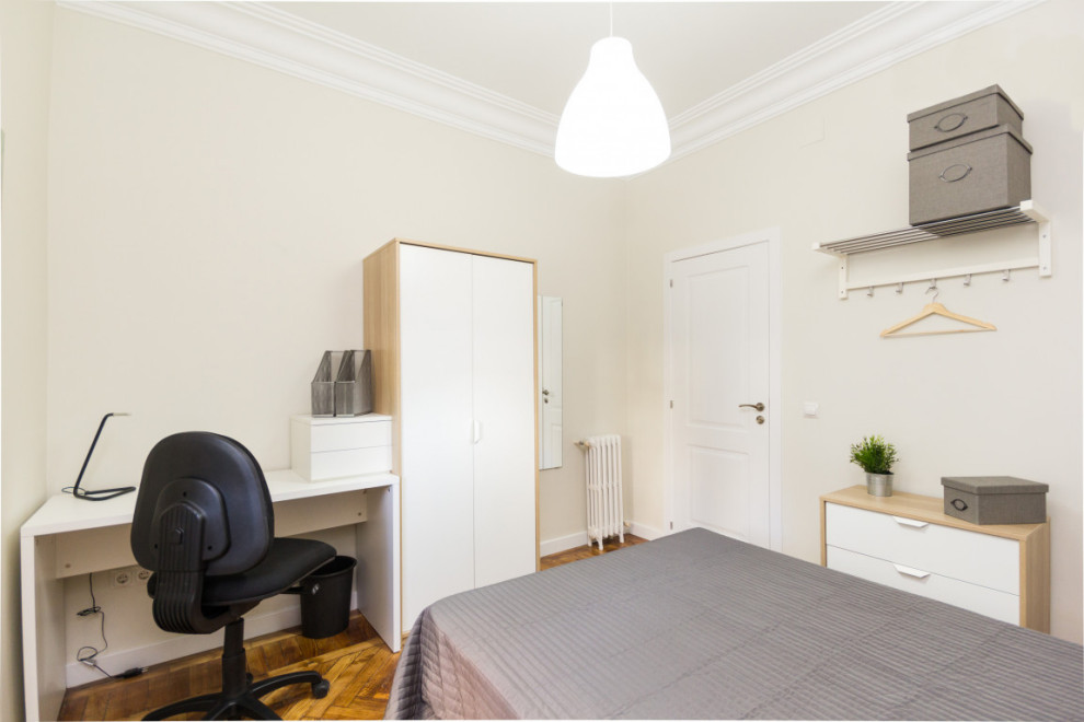 Esempio di una camera matrimoniale minimalista di medie dimensioni con pareti beige, pavimento in legno massello medio e pavimento marrone