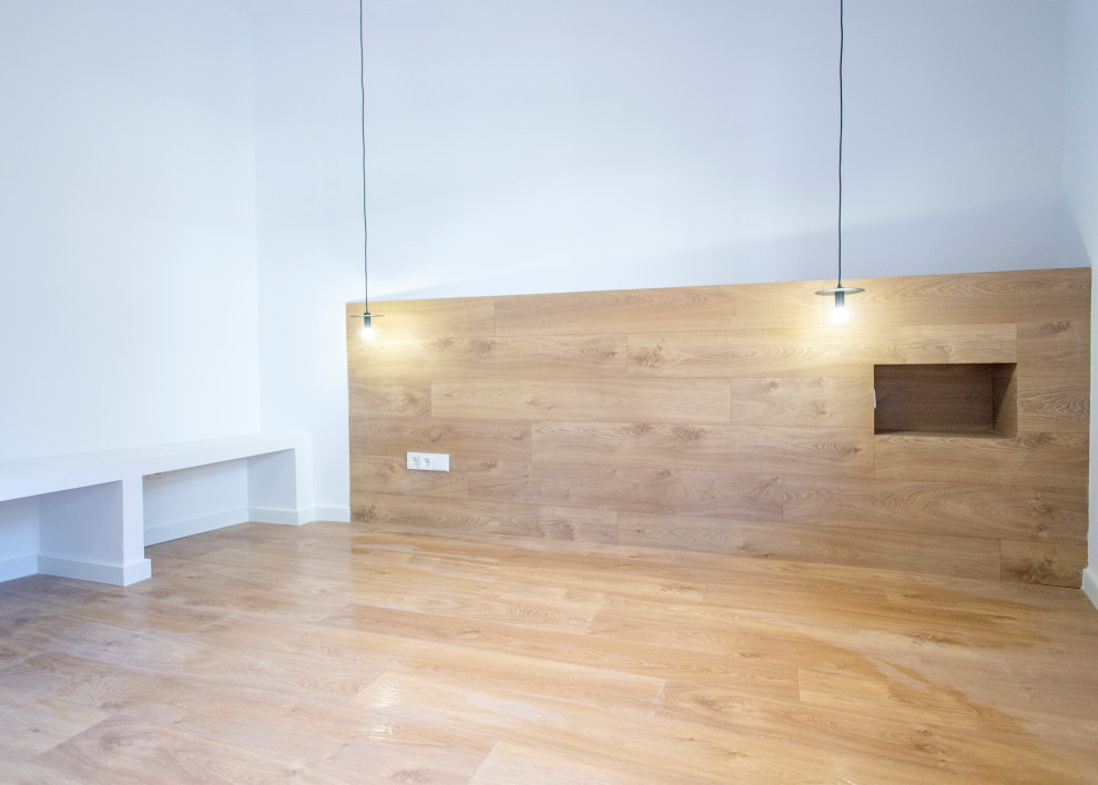 Modelo de dormitorio principal contemporáneo grande sin chimenea con paredes blancas, suelo de madera en tonos medios y suelo marrón