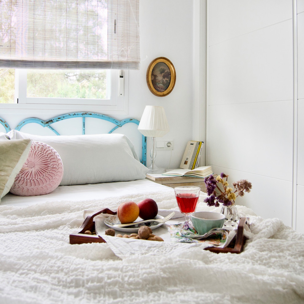 Ejemplo de dormitorio principal ecléctico de tamaño medio con paredes blancas, suelo laminado y suelo marrón