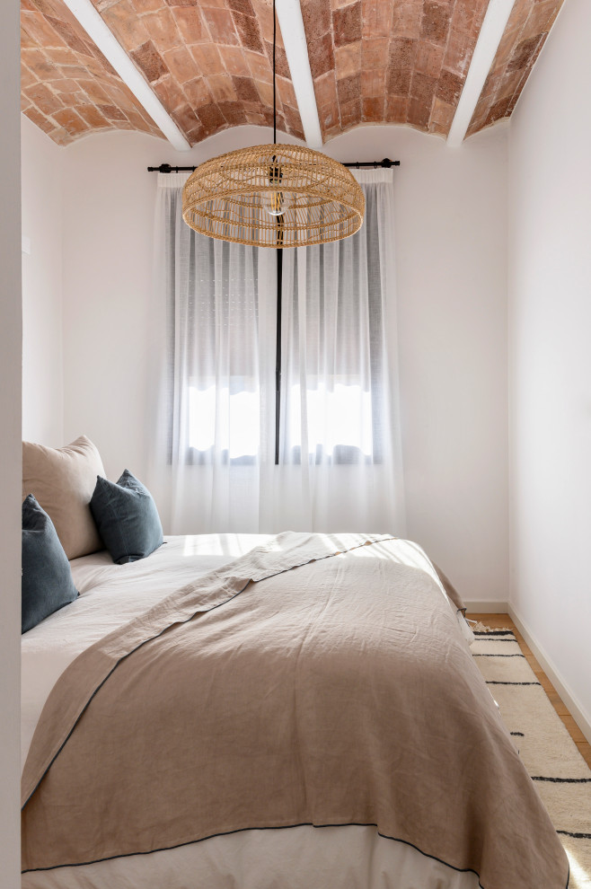 На фото: спальня в средиземноморском стиле с белыми стенами, паркетным полом среднего тона, коричневым полом и сводчатым потолком