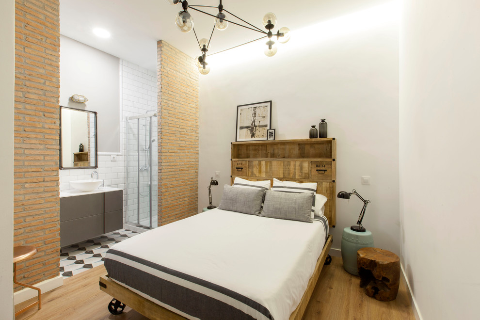 マドリードにある中くらいなインダストリアルスタイルのおしゃれな客用寝室 (青い壁、無垢フローリング、暖炉なし、茶色い床) のレイアウト