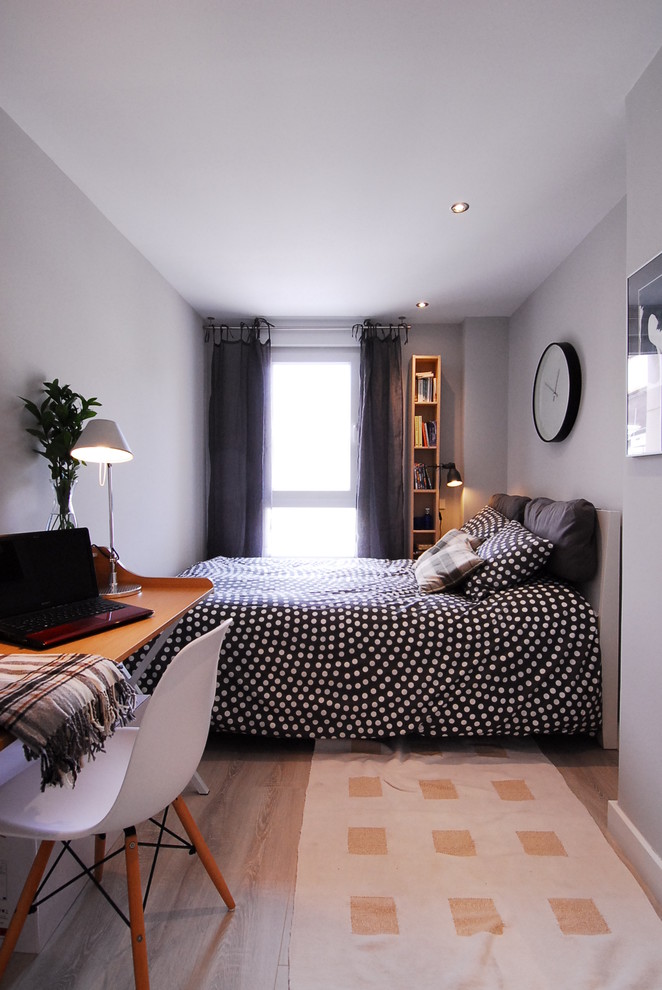 Cette photo montre une chambre parentale tendance de taille moyenne avec un mur blanc, parquet clair et aucune cheminée.