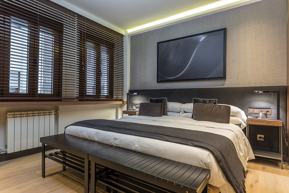 Modelo de habitación de invitados contemporánea con paredes grises, suelo de madera clara y suelo marrón