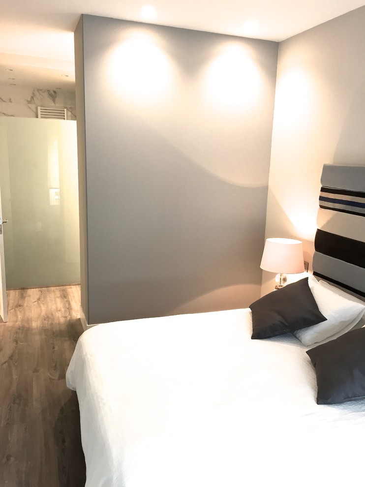 Imagen de dormitorio principal contemporáneo de tamaño medio sin chimenea con paredes blancas y suelo de madera oscura