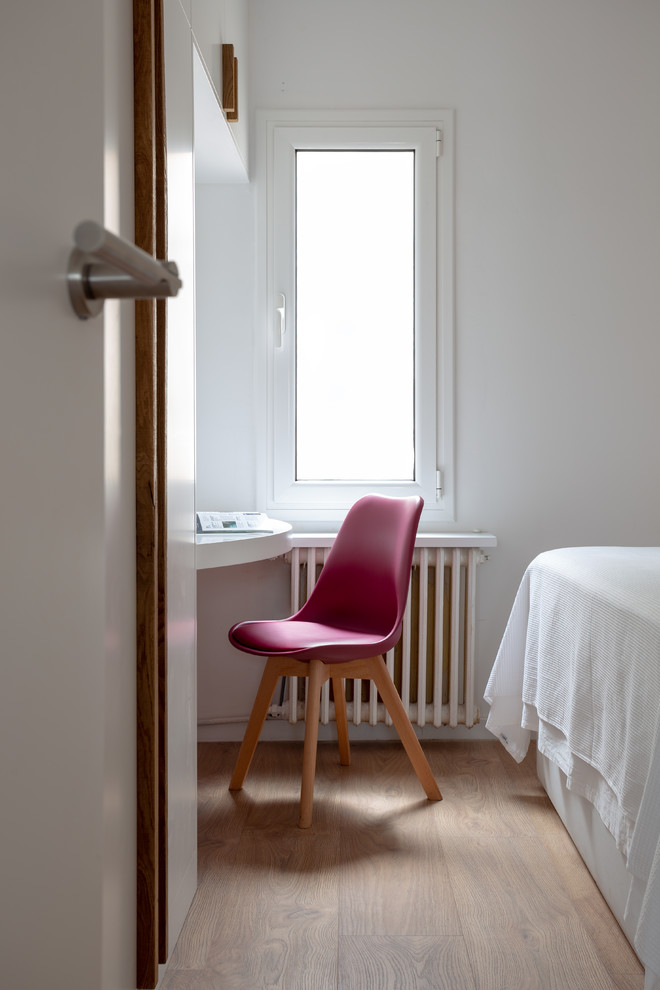 Imagen de dormitorio principal escandinavo de tamaño medio sin chimenea con paredes blancas, suelo de madera en tonos medios y suelo marrón
