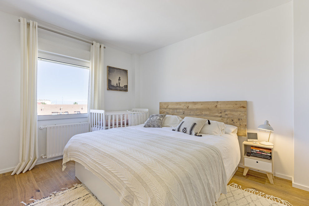 Inspiration för moderna sovrum, med vita väggar, mellanmörkt trägolv och brunt golv
