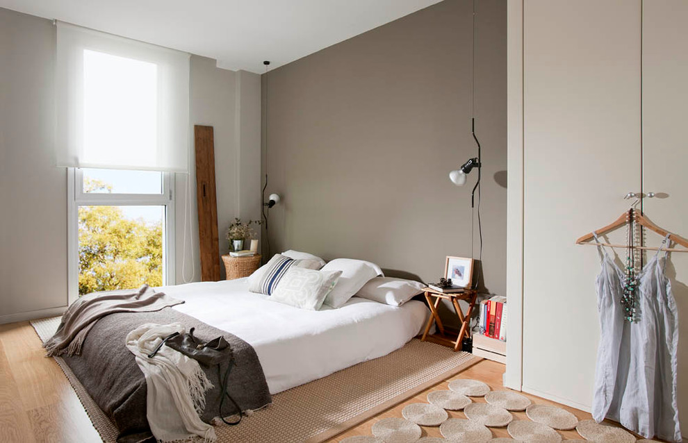 Foto de dormitorio principal escandinavo grande sin chimenea con paredes grises y suelo de madera clara