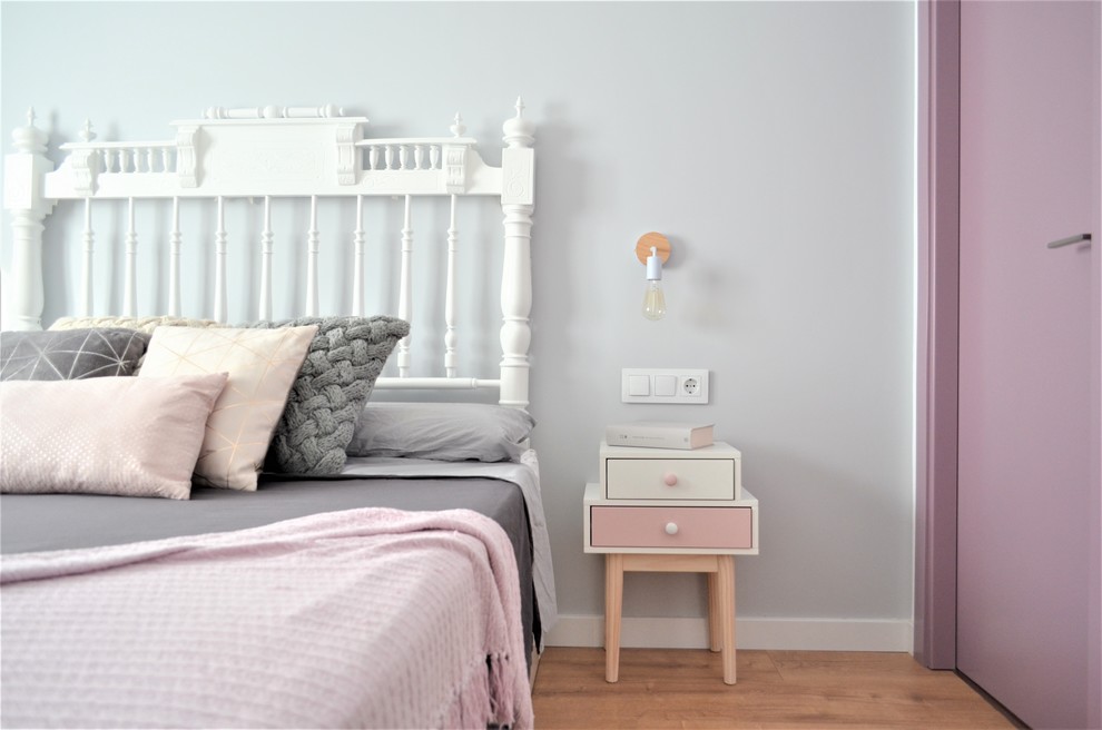 Ejemplo de habitación de invitados nórdica con paredes grises, suelo de madera en tonos medios y suelo beige