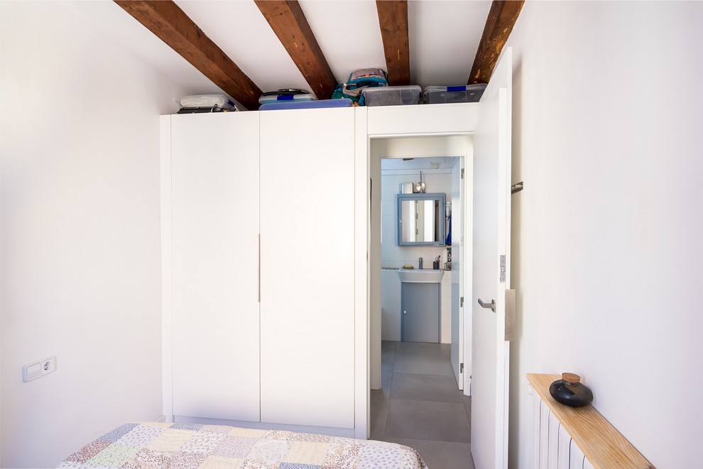 На фото: маленькая хозяйская спальня в современном стиле с белыми стенами, полом из керамогранита и серым полом для на участке и в саду с