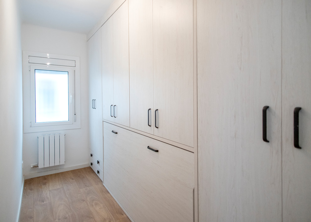 Modelo de habitación de invitados contemporánea de tamaño medio sin chimenea con paredes beige, suelo de madera en tonos medios y suelo marrón